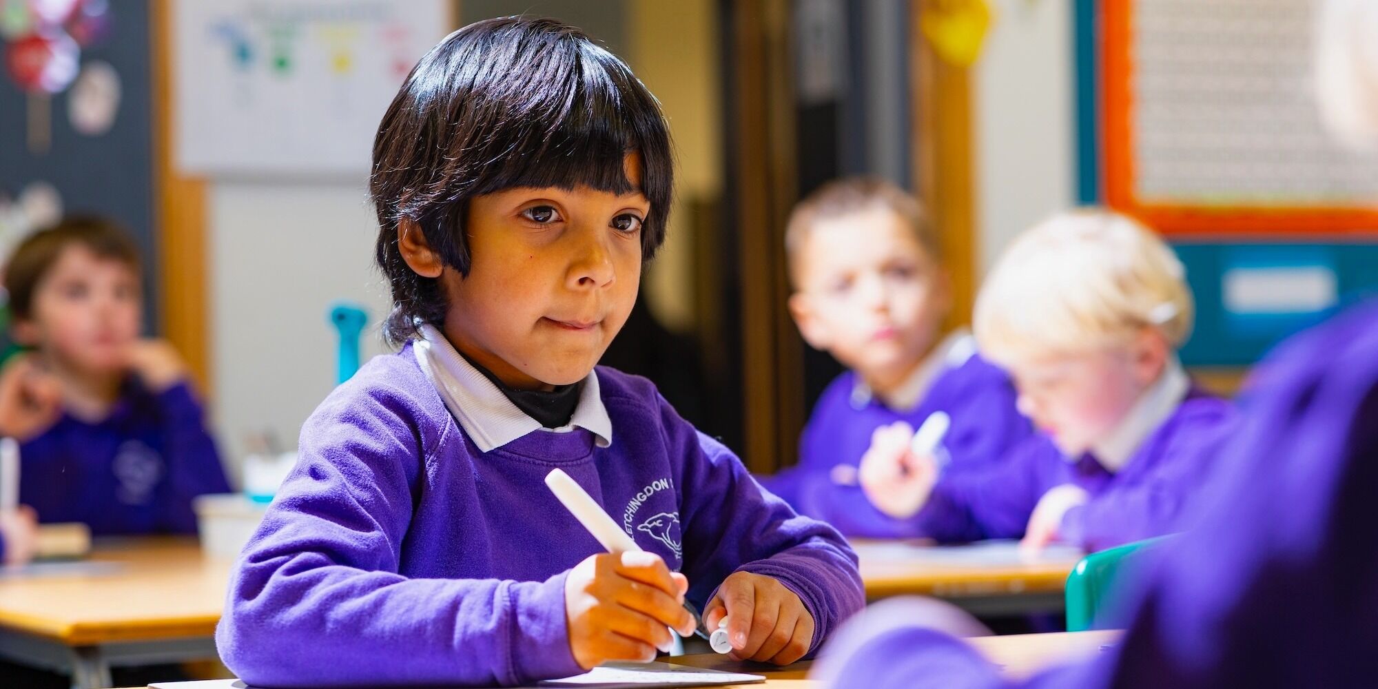 This is a photograph of a pupil using a whiteboard to complete a task.